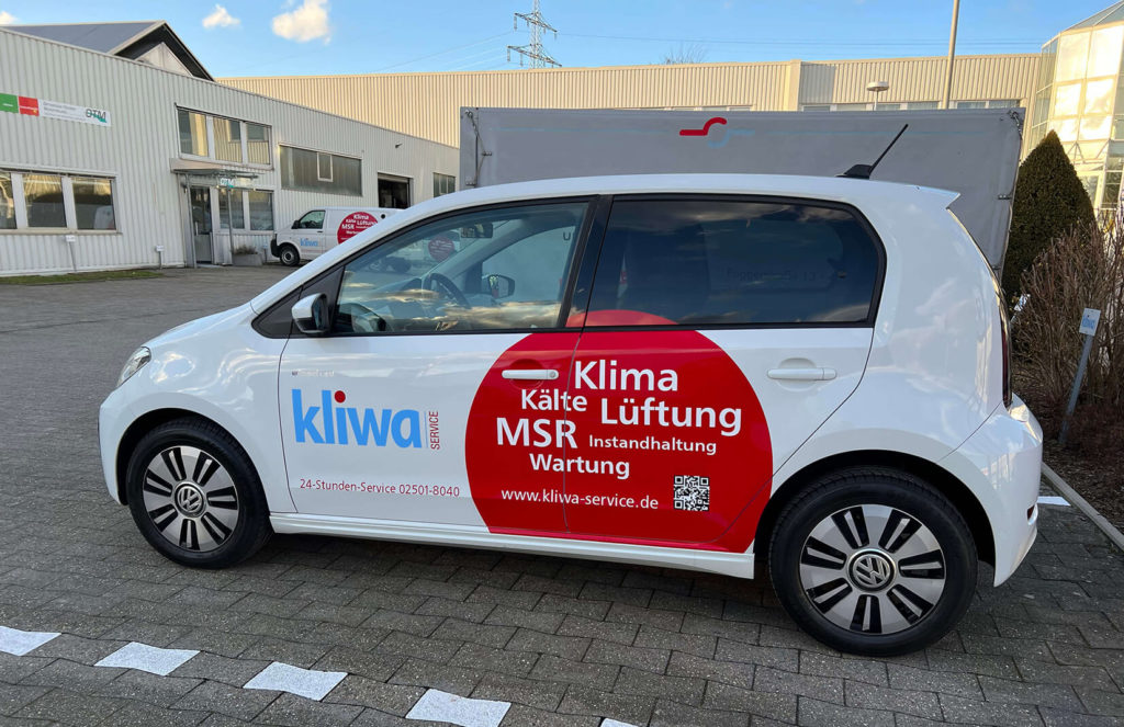 Ein kleiner Firmenwagen, mit Firmenbeklebung.